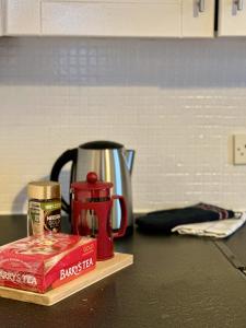 a counter top with a coffee pot and a box of peanuts at City Pulse Apartment in Waterford