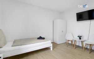 a white room with a bed and a table and chairs at BEGE APARTMENTS: WORKSPOT in Gelsenkirchen