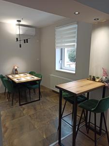 een eetkamer met een tafel en groene stoelen bij Dream House in Vršac