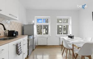 a kitchen with white cabinets and a table and chairs at BEGE APARTMENTS: WORKSPOT in Gelsenkirchen
