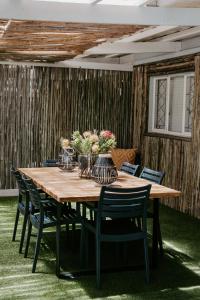 a wooden table with chairs and vases on it at Lavender BnB in East London