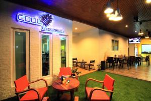 a restaurant with a table and chairs and a dining room at Cool Residence - SHA Plus in Phuket Town