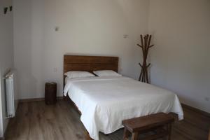 a bedroom with a large white bed and a wooden floor at Casa da Teresinha in Bragança