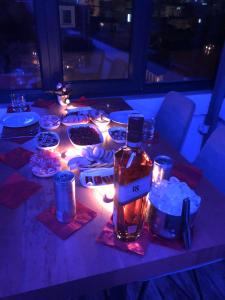 a table with a bottle of alcohol and lights on it at MARDİA CİTY OTEL in Istanbul