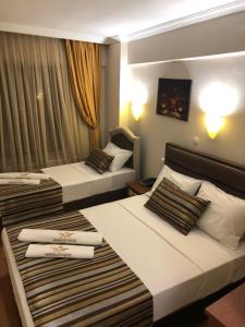 twee bedden in een hotelkamer met handdoeken erop bij MARDİA CİTY OTEL in Istanbul