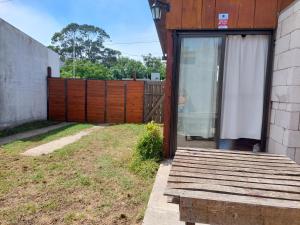 un patio trasero con una valla de madera y una puerta corredera de cristal en Casa de Veraneo - Miramar - en Miramar