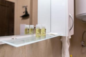 a shelf in a bathroom with three glass jars on it at City Central 1-Bed Apartments in Plovdiv