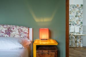 a lamp on a night stand next to a bed at Agriturismo Nonno Luigino in Vico Equense