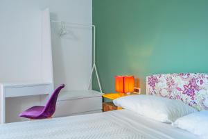 a bedroom with a bed and a purple chair at Agriturismo Nonno Luigino in Vico Equense