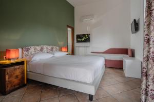 a bedroom with a bed and a couch and a table at Agriturismo Nonno Luigino in Vico Equense