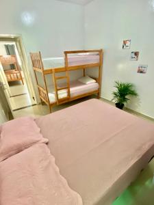 a bedroom with two bunk beds and a potted plant at Casa Apuama in Ubajara