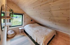 a bedroom in a log cabin with a bed and a window at Gorgeous Home In Jsenfjorden With Sauna in Gullingen