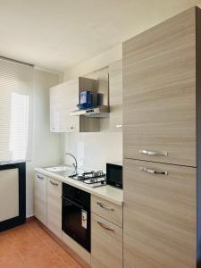 a kitchen with wooden cabinets and a stove at B&B Panta Rei in Arezzo