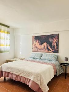 a bedroom with a bed with a painting on the wall at B&B Panta Rei in Arezzo