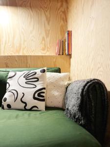 a green couch with a pillow on it with a pillow at Bayda's Tiny House in Sprimont