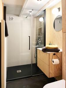 uma casa de banho com um chuveiro e um lavatório. em Bayda's Tiny House em Sprimont