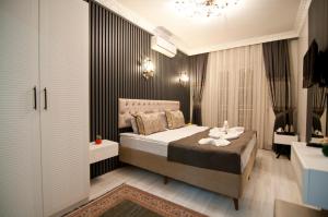 een slaapkamer met een bed en een kroonluchter bij Hotel Broken Column in Istanbul