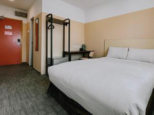 uma grande cama branca num quarto de hotel em The Concept Hotel Melaka City em Malaca