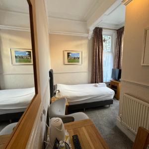 a hotel room with two beds and a mirror at Fairlawns Guest House in Banbury