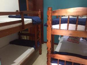a bedroom with two bunk beds and a ladder to a bunk bed at Canto da Praia Suítes in Arraial do Cabo