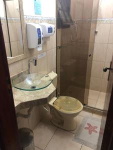 a bathroom with a toilet and a sink and a shower at Canto da Praia Suítes in Arraial do Cabo