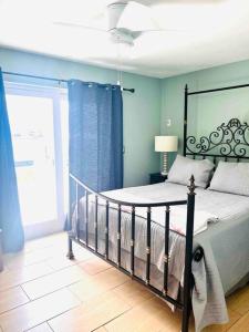 een slaapkamer met een bed met blauwe muren en een raam bij Cozy 2 bedrooms home by the water in Cape Coral