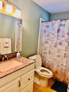 een badkamer met een toilet en een douchegordijn bij Cozy 2 bedrooms home by the water in Cape Coral
