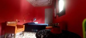 a red room with a bed and a chair at Casa Artistica 2 in Gandía