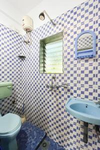 a bathroom with a blue toilet and a sink at SPACELAND Mandrem in Mandrem