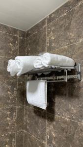 łazienka z białymi ręcznikami na ścianie wyłożonej kafelkami w obiekcie Airport Hotel 24 w Taszkiencie