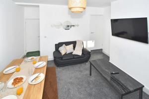 a living room with a table and a couch at Emerald Terrace by YourStays in Stoke on Trent