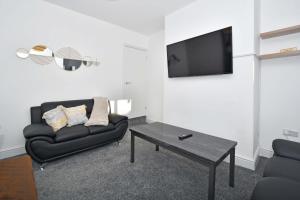 a living room with a couch and a coffee table at Emerald Terrace by YourStays in Stoke on Trent