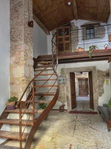 a wooden spiral staircase in a stone building at DOMUS VELA in Fornelli