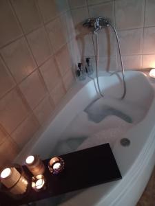 El baño incluye una bañera blanca con velas. en Elegante room en Serres