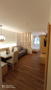 - un salon avec un canapé et une table dans l'établissement Residence Montebel, à Tesero