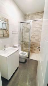 een badkamer met een toilet, een wastafel en een douche bij Bliss Apartments T0 - Maria (On the beach) in Mindelo