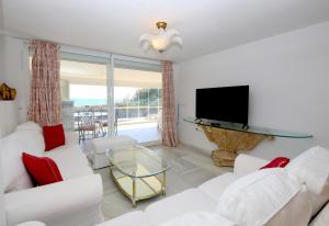 a living room with white furniture and a flat screen tv at Townhouse SEASCAPE in Estepona