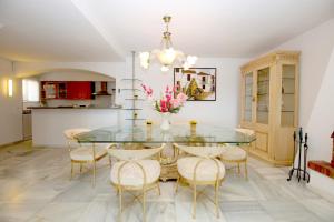 a dining room with a glass table and chairs at Townhouse SEASCAPE in Estepona