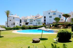 a resort with a swimming pool and a building at Townhouse SEASCAPE in Estepona