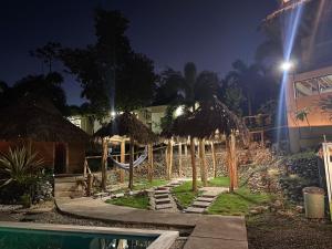 un complejo con parque infantil con sombrillas y piscina en Hotel Vista Bonita, en Parrita