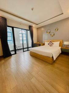 a bedroom with a large bed and large windows at ENJOY HOME in Da Nang