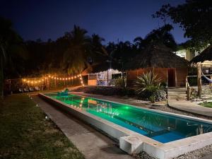 uma piscina à noite com luzes ao redor em Hotel Vista Bonita em Parrita