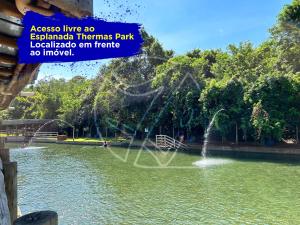 a fountain in a pond in a park at Casa Para Temporada - Com Acesso ao Rio Thermal in Rio Quente
