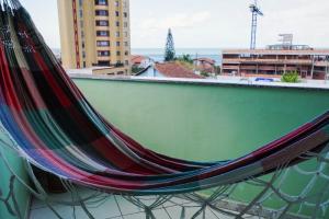 a hammock sitting on the side of a building at Apartamento na praia - Canto da Sereia in Piçarras