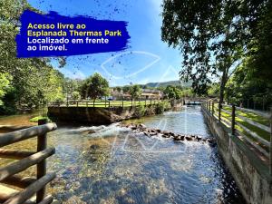 un río con una valla en primer plano en Casa Para Temporada - Com Acesso ao Rio Thermal en Rio Quente