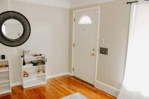 a hallway with a white door and a mirror at Cozy house near Lake Erie, 10 minutes to Downtown. in Cleveland