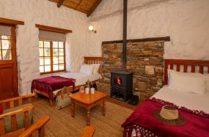 a room with two beds and a stone fireplace at Mount Ceder in De Straat