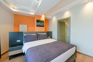 1 dormitorio con 1 cama grande y paredes de color naranja en Rise Inn Hotel, en Estambul