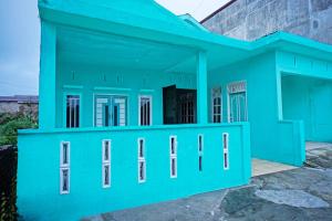 a blue house with a garage at OYO 93298 Barito House in Pematangsiantar