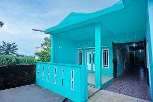 a blue building with an open door at OYO 93298 Barito House in Pematangsiantar